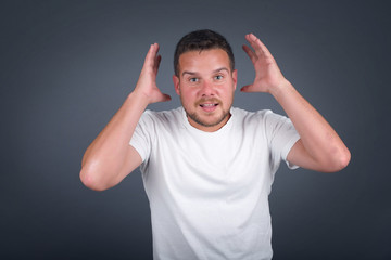Excited  overjoyed man screams after recieving good news, keeps hands on head, can't believe it.
