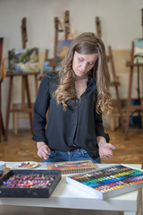 Fototapeta premium Portrait of a woman artist crayon painting in the art studio.