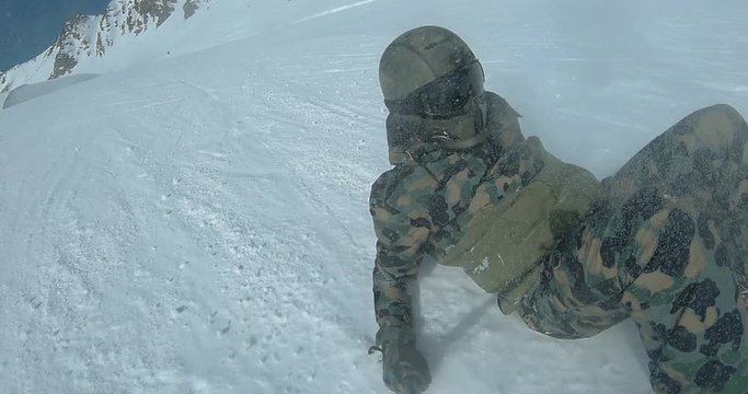 POV snowboarder falling hard on a slope, filming himself with a selfie stick. 4K UHD