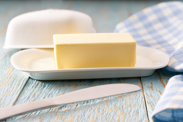 whole block butter on a blue wooden table, selective focus.