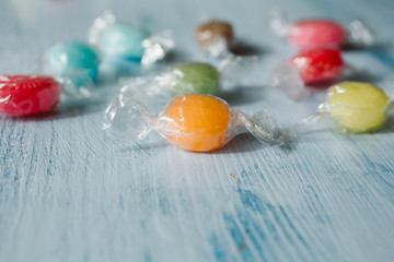 Heap of colorful sugar candies on wooden background. Close up view of fruity candies as texture and background.