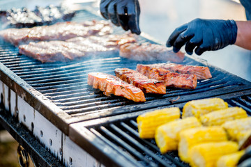 Cooking BBQ Fish.Gloved hands turn pieces of fish on the grill.