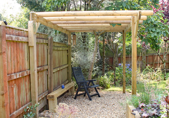 A quiet relaxing and shady area in a back garden under a pergola and magnolia tree