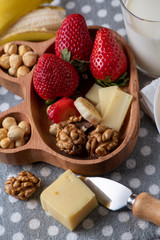 fresh strawberries and  nuts on a wooden plate