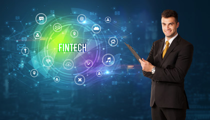 Businessman thinking in front of technology related icons and FINTECH inscription, modern technology concept