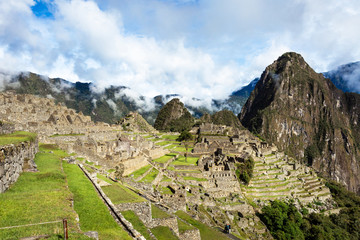 Сlassic view with cloudy sky of Machu Picchu located in the Cusco Region, UNESCO World Heritage Site, New Seven Wonders of the World.