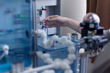 Engineering students working in the lab. Students are adjusting an electrical's components inside lab.