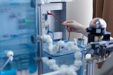 Engineering students working in the lab. Students are adjusting an electrical's components inside lab.