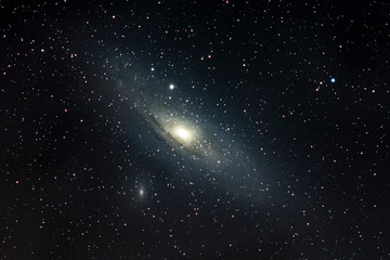 Obraz na płótnie Canvas A view of Andromeda spiral Galaxy (M31) and its companions M32 and M110 Galaxies. Billions of stars live on this three galaxies and inside it bright galactic core a black hole resides 