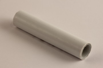 A part of white PN 10 type metal-plastic pipe 16 mm, close up plumbing fixtures on white background