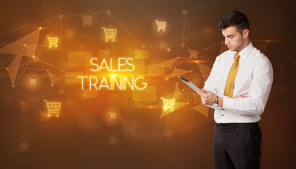 Businessman with shopping cart icons and SALES TRAINING inscription, online shopping concept