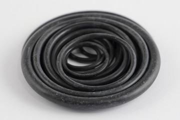 A many black rubber O-Rings close up, plumbing fixtures on white background