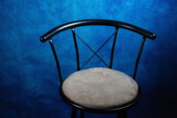 black and tan metal chair with blue background