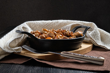 Cast iron pan with fried champignon