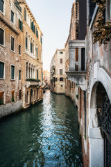 Fototapeta na wymiar Colorful houses along narrow canal waters of Venice Italy