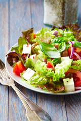 Salad with Olives, Tomatoes and Feta Cheese on wooden Background. Healthy Snack Idea.