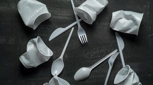 plastic problem concept, stop motion animation, place for text, white plastic dishes move on black background 4k