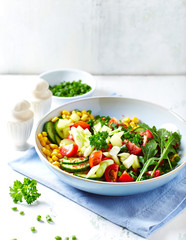 Healthy Salad with Rocket, Cherry Tomatoes. Cucumber and Sweet Corn. Tasty vegetarian snack. Bright wooden background. 