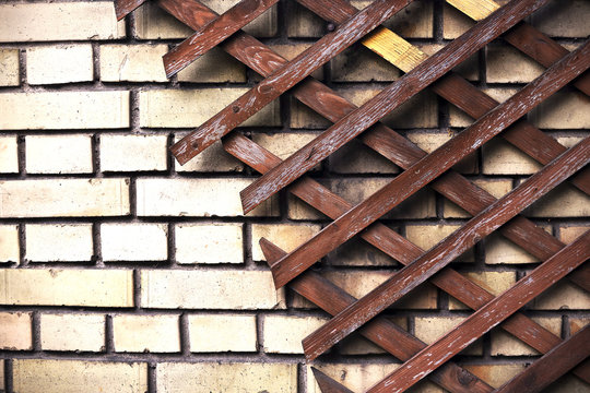 Wooden diamond diagonal trelis on brick wall