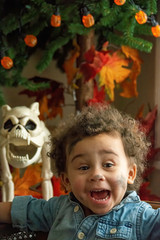 Little black girl at halloween in front of a halloween tree
