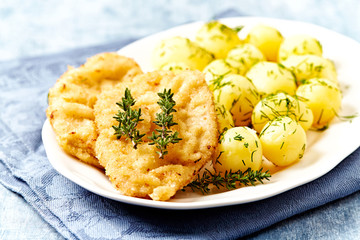 Pork Schnitzel with potatoes and fresh herbs.
