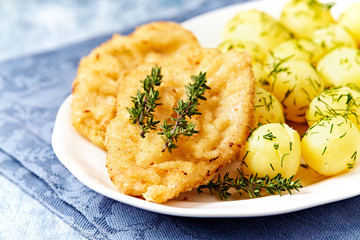 Pork Schnitzel with potatoes and fresh herbs.