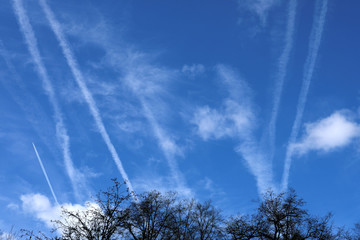 Fototapeta na wymiar Flugzeug am Himmel mit Kondesstreifen und Wolken - Stockfoto