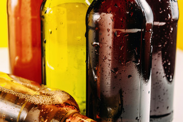 Bottles of beer in different colors. Light and dark beer. Beer background for advertising, chilled...