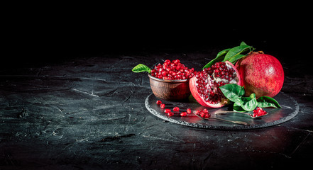 Sweet, ripe and fresh garnet on dark background. Juicy heap of pomegranate seeds