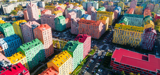 Urban landscape of colorful buildings. Aerial view of the colorful buildings in the European city in the morning sunlight. Cityscape with multicolored houses, cars on the street in Kiev, Ukraine.