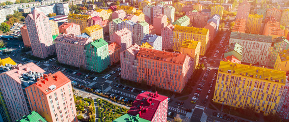 Urban landscape of colorful buildings. Aerial view of the colorful buildings in the European city in the morning sunlight. Cityscape with multicolored houses, cars on the street in Kiev, Ukraine.