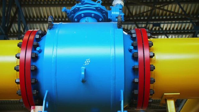 blue tank on pipeline at gas compression station closeup
