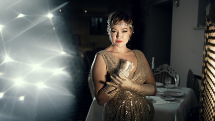 a woman in the image of 20s, looks like a frame from old films, on the head of a diodema, a...