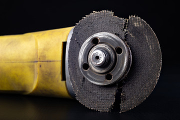 Damaged cutting disc for metal in an angle grinder. Power tools in a locksmith's workshop for...