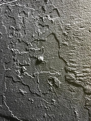 Rough grey concrete wall surface with shadows, uneven blurry texture