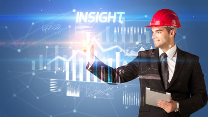 Handsome businessman with helmet drawing INSIGHT inscription, architecture business plan concept