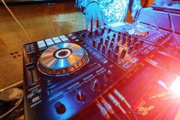 DJ mixer controller. Faders and switches of silver audio mixing console in nightclub. Selective...