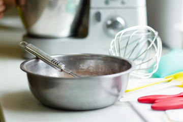 Woman professional pastry chef prepares chocolate dough.