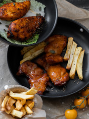 food, fried chicken legs with french fries, sauces, greens in a pan, grilled, serving example