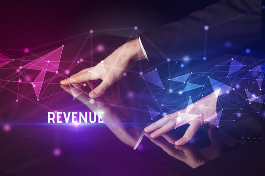 Businessman touching huge screen with REVENUE inscription, modern technology business concept