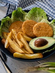 food, chicken medallions with avocado, cherry tomatoes, herbs on the table, serving example