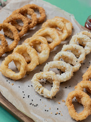 food, squid rings breaded with sauces on a black background, serving example