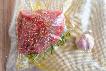 marinated sous vide steak in a vacuum bag with olive oil and rosemary