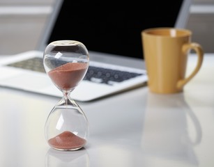 Hourglass on office desktop.