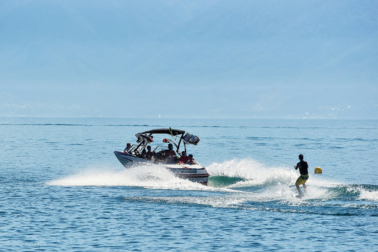 Motorboat with man wakeboarding in Lake Geneva in Lausanne, Switzerland