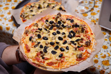 Overhead shot of friends at a table sharing take-away pizzas