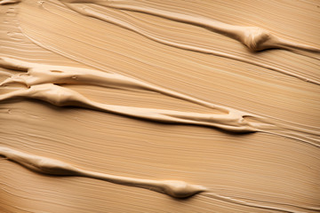 Foundation, concealer, face make-up smudge, smear. Cosmetic liquid foundation or cream beige color smudge, smear, stroke. Contouring, Make up smears background. Brush. Foundation texture.