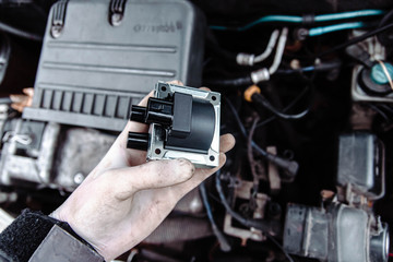 replacing the ignition coil of a car. - obrazy, fototapety, plakaty