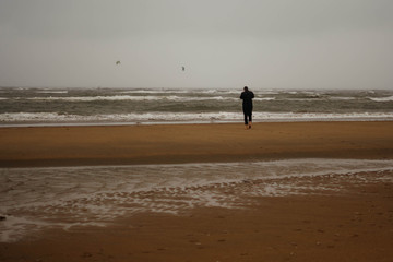 Fototapeta na wymiar man walking on the beach at sunset