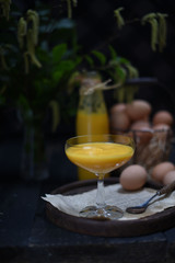 Homemade Egg Liqueur on dark vintage wooden background.